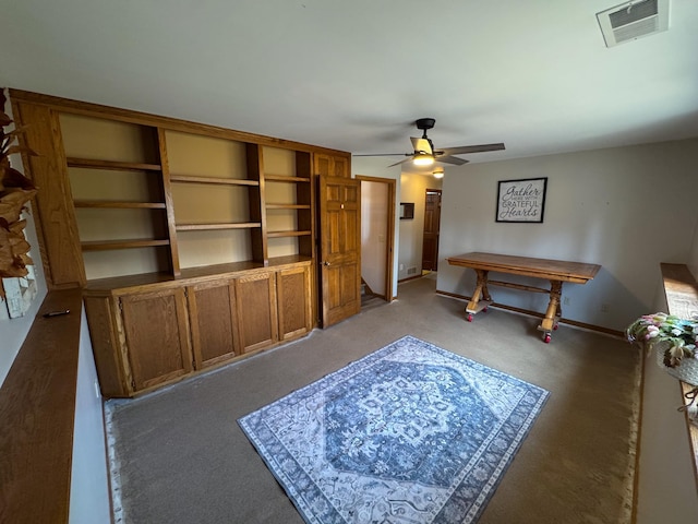 interior space with carpet, visible vents, ceiling fan, and baseboards