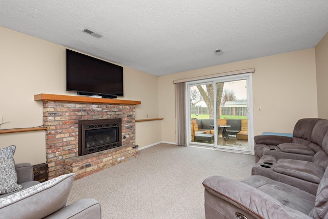 carpeted living room with a textured ceiling, visible vents, and a fireplace