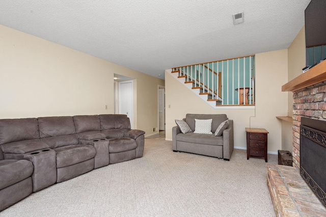 carpeted living room with a brick fireplace, stairs, a textured ceiling, and visible vents