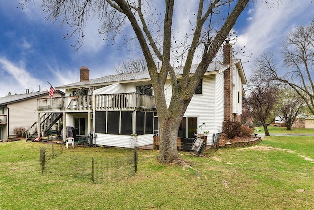 back of house with a lawn, a chimney, a sunroom, and stairway