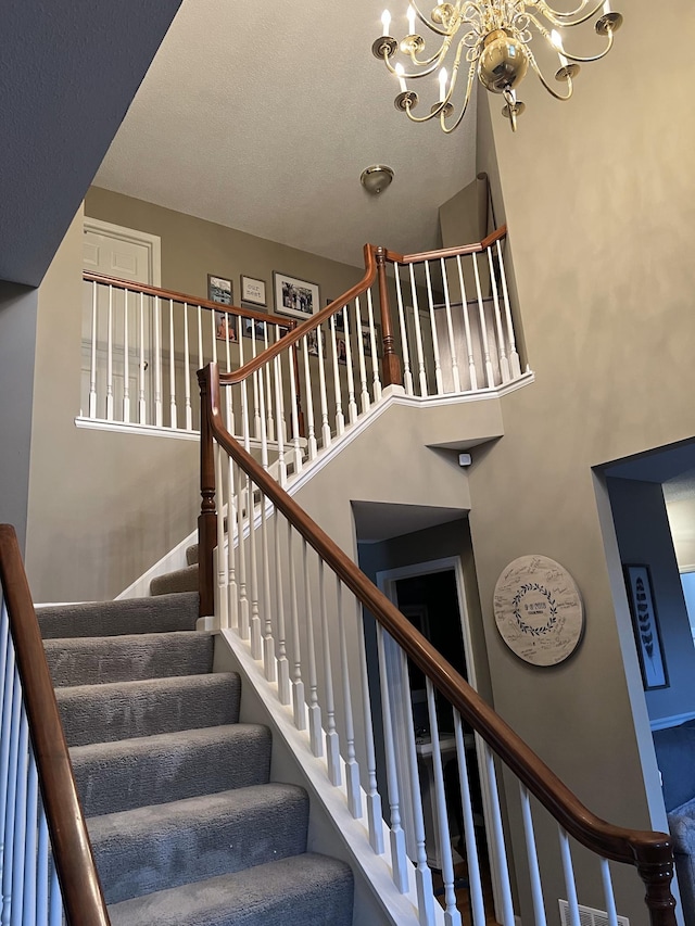 stairs with an inviting chandelier and a high ceiling