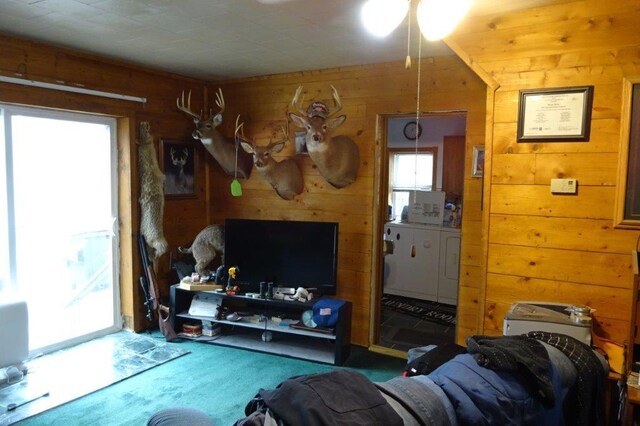 338 40th St, Clear Lake, WI 54005 - living room featuring a ceiling fan, wood walls, and washer and clothes dryer