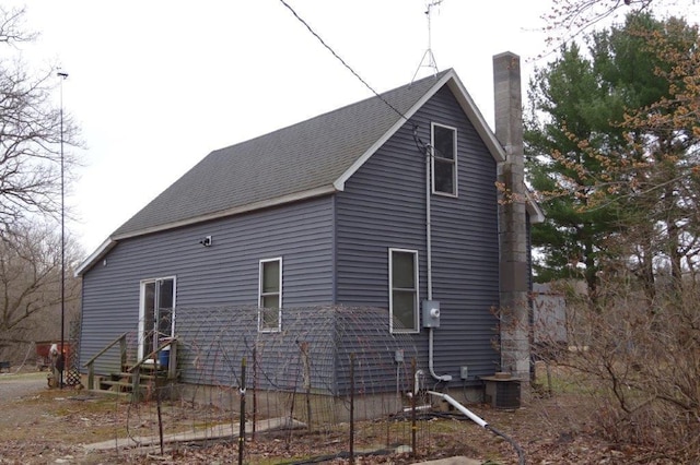 338 40th St, Clear Lake, WI 54005 - view of side of home with central air condition unit, a shingled roof, and a chimney