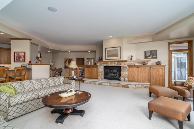 carpeted living area featuring a stone fireplace and recessed lighting
