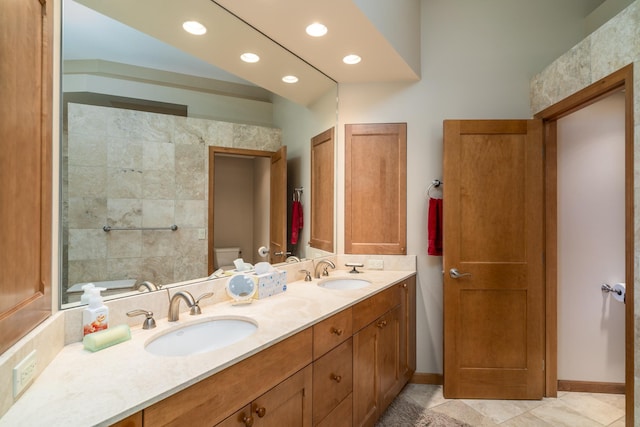 bathroom featuring a sink, recessed lighting, toilet, and double vanity