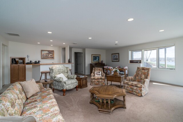 living room with recessed lighting, visible vents, and light carpet