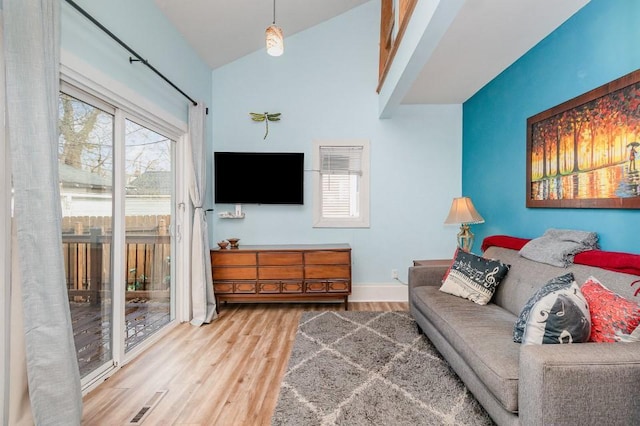 2530 Pleasant Ave, Minneapolis, MN 55404 - living area featuring baseboards, vaulted ceiling, wood finished floors, and visible vents