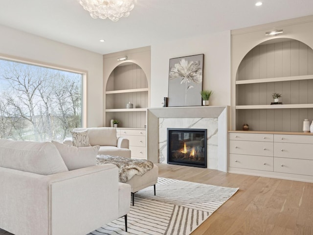 5010 Millie Rd SW, Rochester, MN 55902 - living room with built in features, a fireplace, light wood-type flooring, a notable chandelier, and recessed lighting
