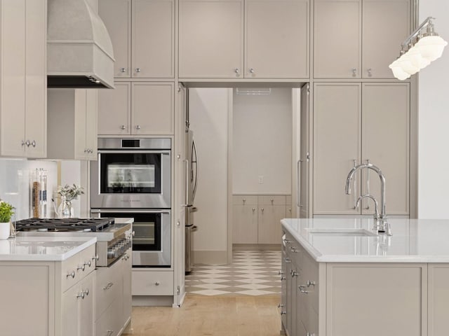 5010 Millie Rd SW, Rochester, MN 55902 - kitchen with a sink, light countertops, an island with sink, premium range hood, and stainless steel appliances