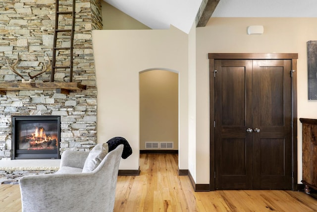 3420 Fairview Ave N, Arden Hills, MN 55112 - living room with arched walkways, light wood-style floors, a stone fireplace, and baseboards