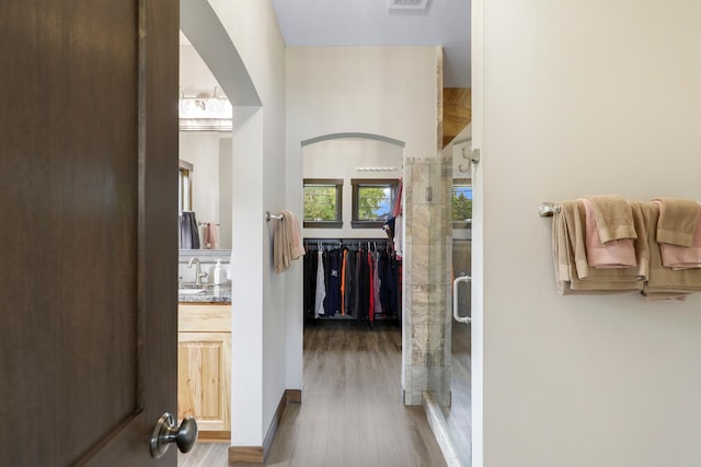 3420 Fairview Ave N, Arden Hills, MN 55112 - hallway with a sink, wood finished floors, and arched walkways
