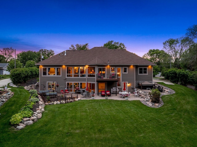 3420 Fairview Ave N, Arden Hills, MN 55112 - back of house at dusk with a patio area, a lawn, and a shingled roof