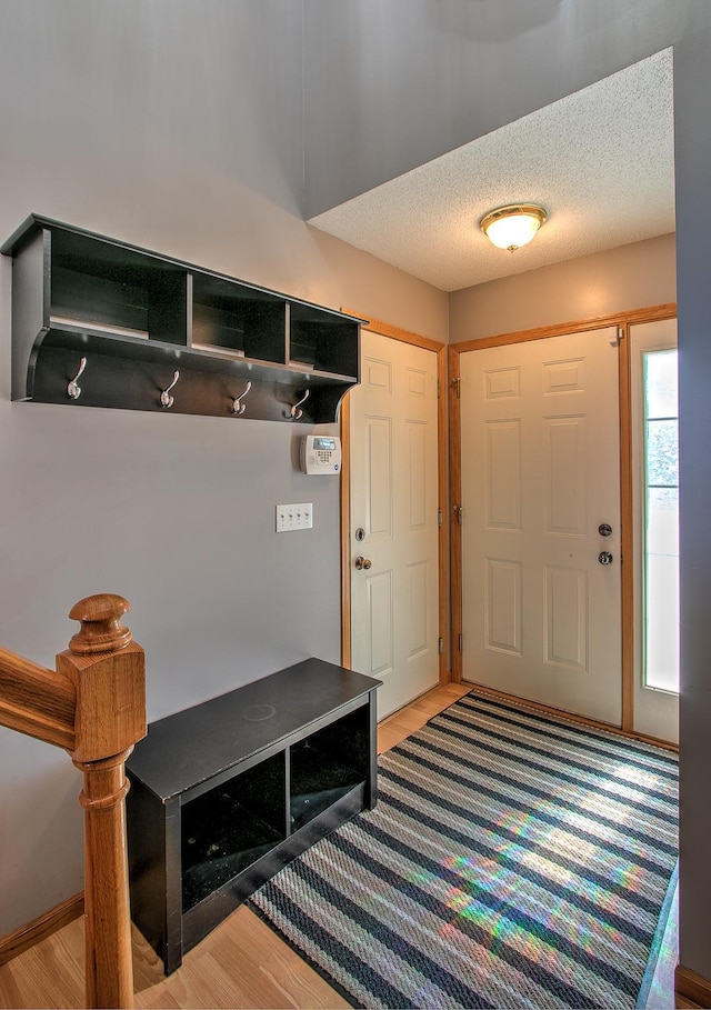 mudroom with a textured ceiling and light wood-style flooring