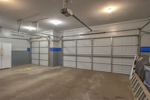 garage with freestanding refrigerator and a garage door opener
