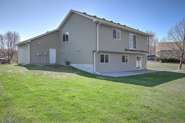 rear view of house with central AC unit, a patio area, and a yard