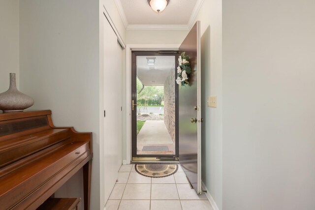 entryway with crown molding, light tile patterned floors, and baseboards