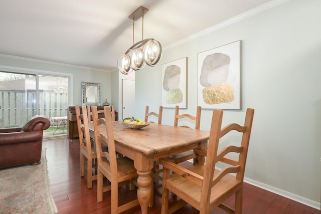 dining space featuring ornamental molding, wood finished floors, a chandelier, and baseboards