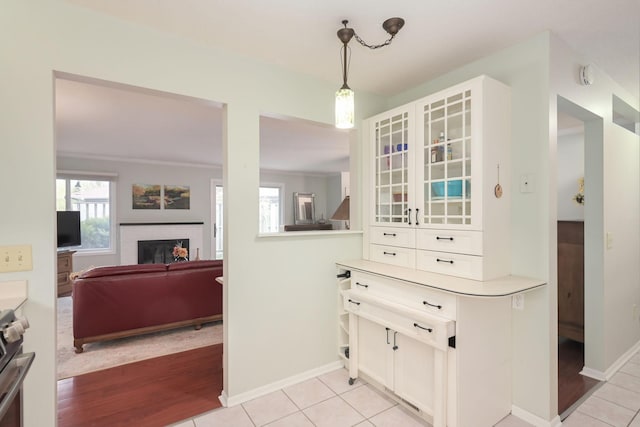 dining area with a fireplace, baseboards, and light wood-style floors