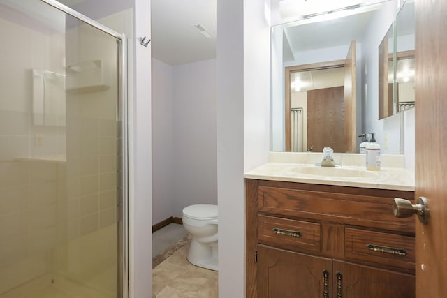 bathroom featuring a shower stall, toilet, vanity, baseboards, and tile patterned floors