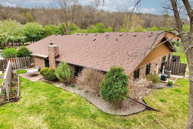 view of side of home featuring a shingled roof, a chimney, a patio area, and central air condition unit