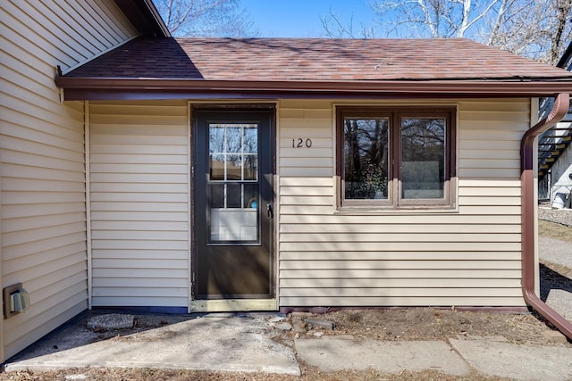 property entrance featuring roof with shingles