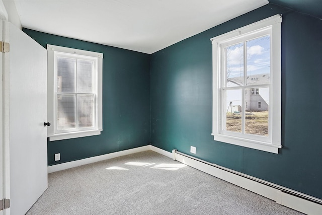 unfurnished room with baseboard heating, a wealth of natural light, and carpet