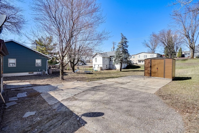 view of street with a residential view, concrete driveway, and a gated entry