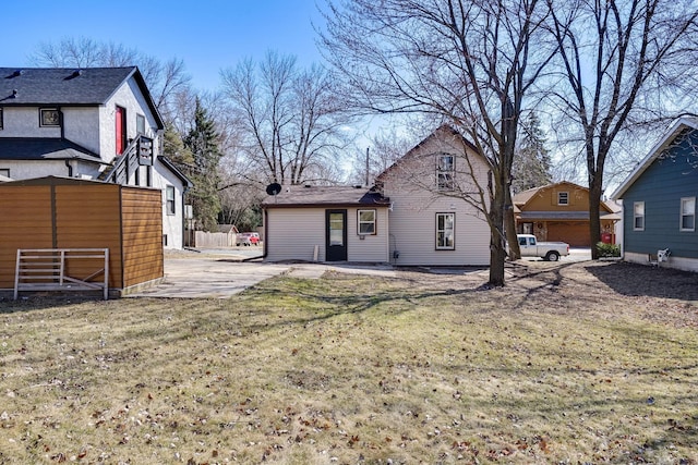 back of house featuring a lawn and fence