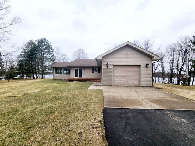 ranch-style house with an attached garage, a front lawn, and aphalt driveway