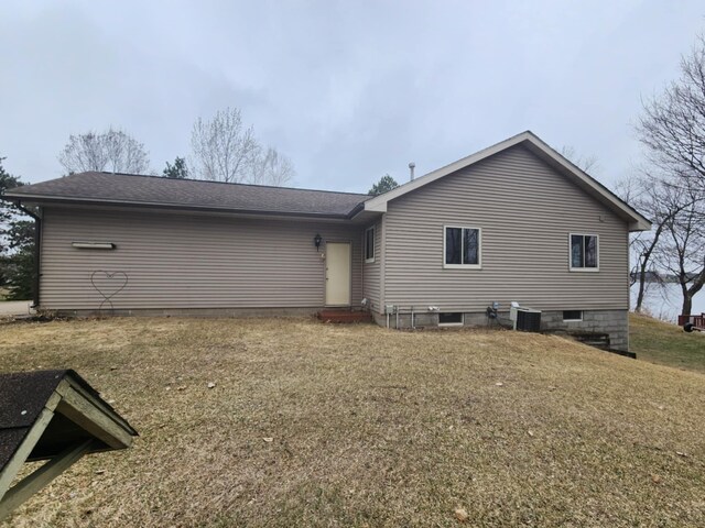 back of house with a lawn, entry steps, and central air condition unit