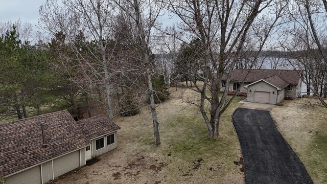 view of yard with a garage and aphalt driveway