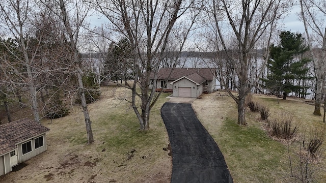 view of front of home with an attached garage, a front lawn, and driveway