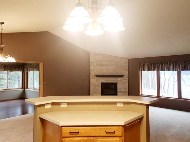 kitchen featuring an inviting chandelier, light carpet, light countertops, open floor plan, and vaulted ceiling
