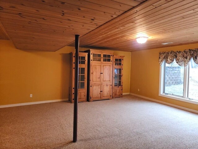 interior space with wood ceiling, baseboards, and light colored carpet
