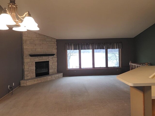 living area with a notable chandelier, vaulted ceiling, carpet, and a fireplace