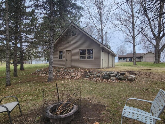 exterior space with a lawn and a fire pit