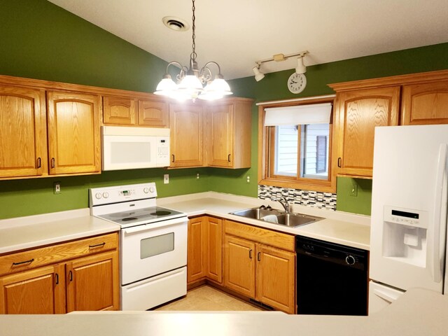 kitchen featuring visible vents, hanging light fixtures, a sink, light countertops, and white appliances