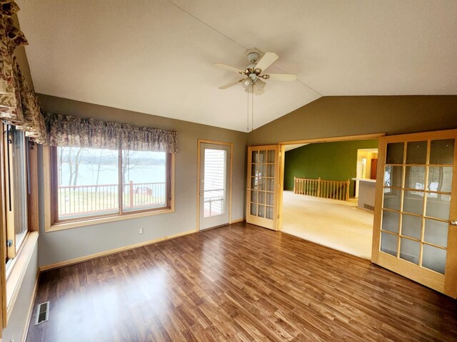 unfurnished room featuring ceiling fan, vaulted ceiling, wood finished floors, and visible vents