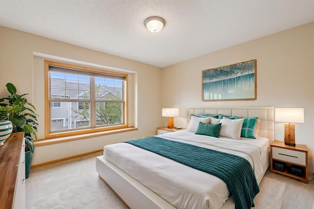 bedroom featuring baseboards and light colored carpet