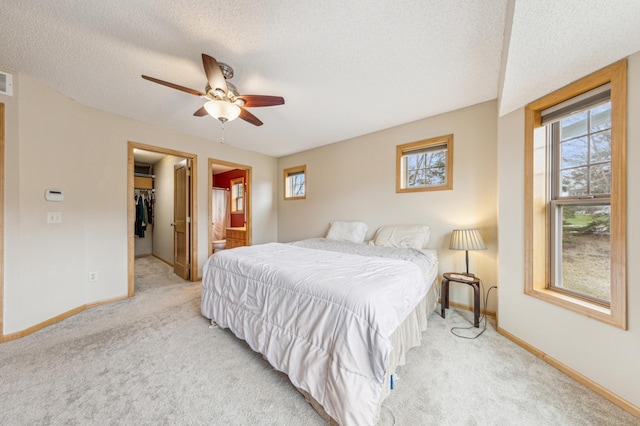 bedroom featuring multiple windows, light carpet, and a textured ceiling