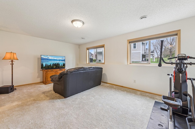 workout room featuring baseboards, a textured ceiling, and light colored carpet