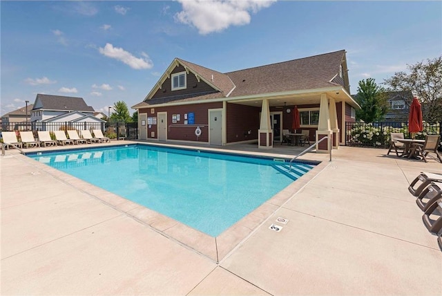 community pool with a patio and fence