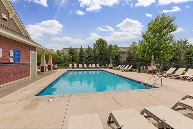 community pool featuring fence and a patio area