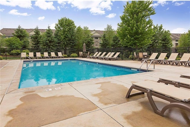 pool with a patio and fence