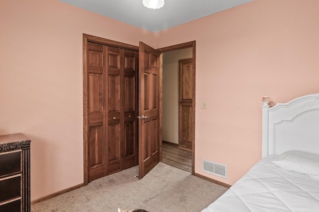 carpeted bedroom with baseboards, visible vents, and a closet