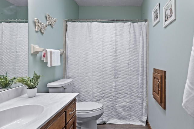 bathroom with vanity, toilet, wood finished floors, and a shower with shower curtain