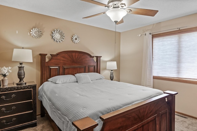 carpeted bedroom with baseboards, ceiling fan, and visible vents