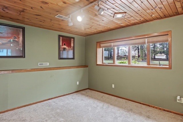 carpeted empty room featuring visible vents, wood ceiling, baseboards, and a healthy amount of sunlight