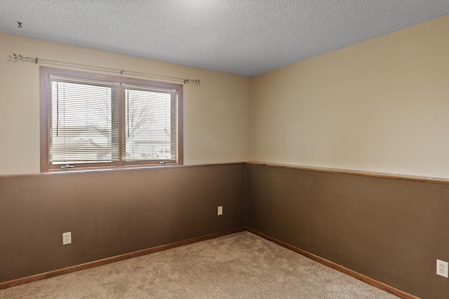 carpeted empty room featuring baseboards and a textured ceiling
