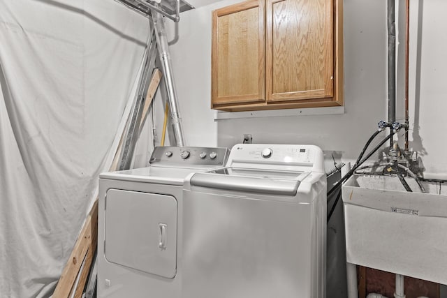 laundry area featuring a sink, cabinet space, and washer and clothes dryer